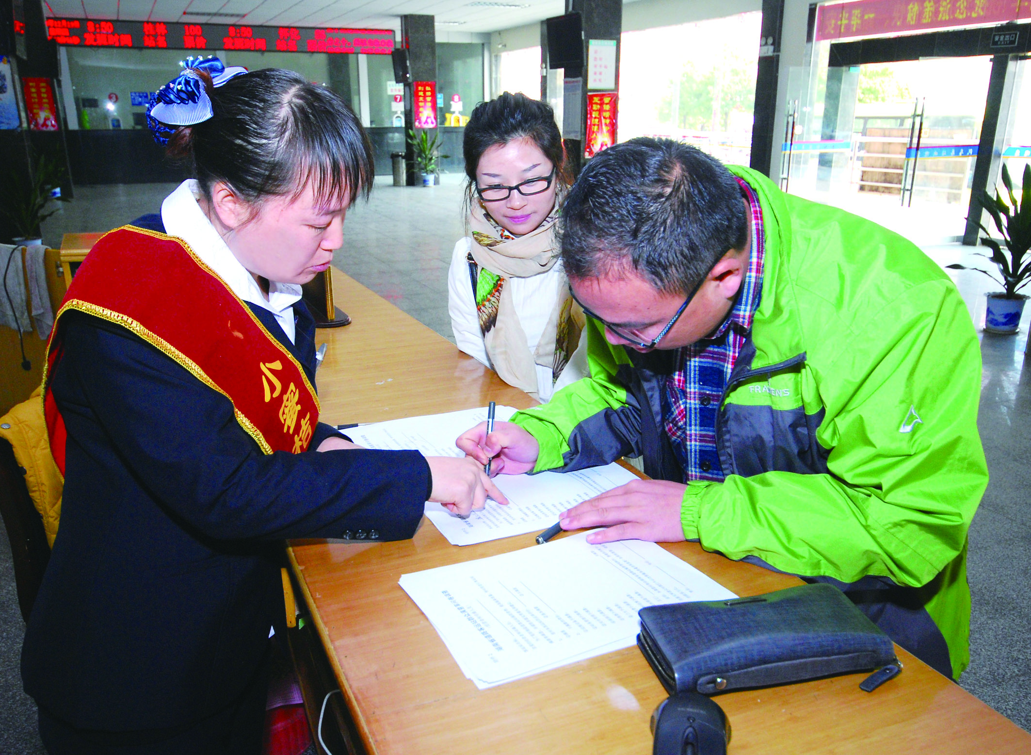 圖為洞口汽車總站站務(wù)人員在熱心為旅客服務(wù)。